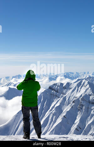 Sciatore rende la foto sulla sommità delle montagne innevate a Nizza il giorno sun. Montagne del Caucaso in inverno, Georgia, regione Gudauri. Foto Stock