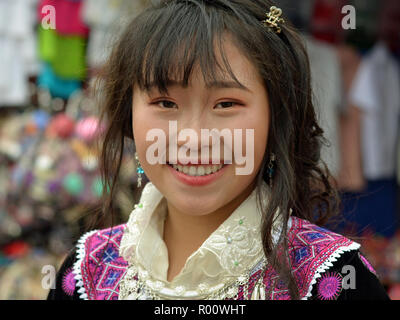 Grazioso fiore vietnamita H'mongs ragazza adolescente weas il suo clan del vestito tradizionale durante il settimanale mercato di domenica. Foto Stock