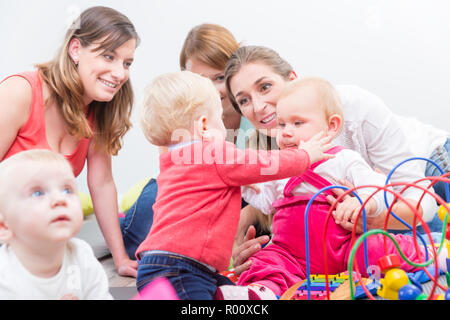 Gruppo di felice giovani madri a guardare la loro cute e i neonati sani Foto Stock