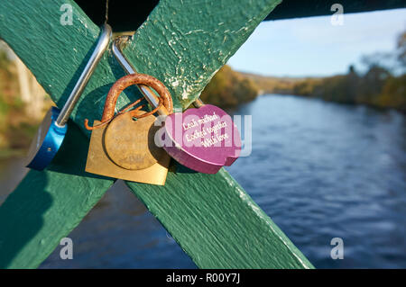 Lucchetti bloccati su di una passerella di ferro sul fiume Tummel a Pitlochry, simbolo di un amore infinito, Scozia Foto Stock