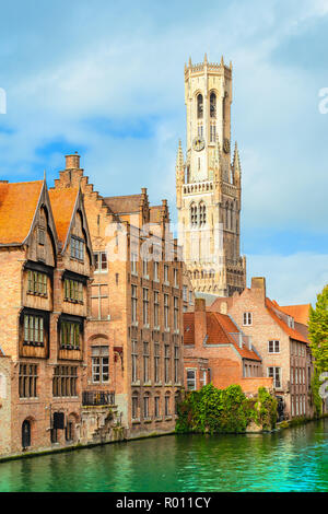 Torre campanaria e vecchie case tradizionali lungo il canale in Bruges, Belgio. Foto Stock
