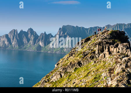 Gli escursionisti sulla cima della montagna Husfjell, vista dal vertice all mountain range Okshornan nel retro, isola Senja, Troms, Norvegia settentrionale, Norvegia Foto Stock