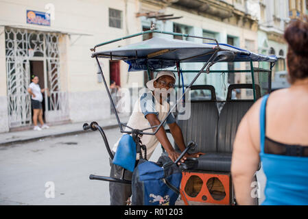 Una bicicletta taxi driver attende per un passeggero a l'Avana, Cuba. Foto Stock