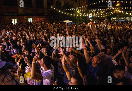 KIEV-11 luglio,2018: gruppo di felice giovani appassionati di musica agitando mani al musicista preferito sul palco. Concerto sulla folla summer festival musicale di bazar di notte Foto Stock