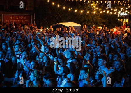 KIEV-11 luglio,2018: un gruppo di giovani di scattare le foto con i telefoni intelligenti sul festival musicale estivo Bazat di notte. Concerto folla in luminose luci blu Foto Stock