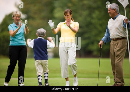 Famiglia lodando giovane ragazzo sul campo da golf Foto Stock