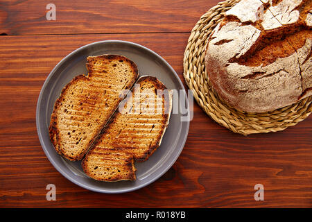 Pane di segale fette biscottate sul legno scuro tabella vista superiore Foto Stock