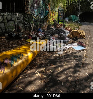 Un senzatetto giovane sonno agitato da Regents Canal accanto a una canoa Foto Stock