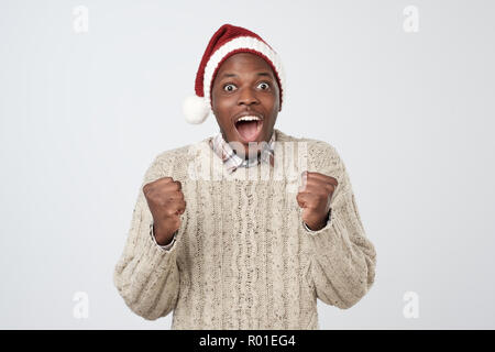 Divertente natale uomo africana in Red Hat su sfondo grigio Foto Stock
