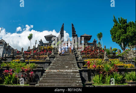 Balinese devota scendere scale, split gate, Candi bentar, Tempio madre Besakih, Pura Agung Besakih Penetaran, Banjar Besakih Foto Stock