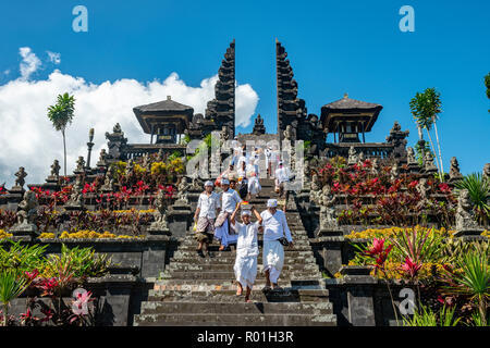 Balinese devota scendere scale, split gate, Candi bentar, Tempio madre Besakih, Pura Agung Besakih Penetaran, Banjar Besakih Foto Stock