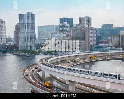 Moderna autostrada con automobili e il treno che conduce ad un ponte. Rainbow Bridge, Tokyo, Giappone. Foto Stock
