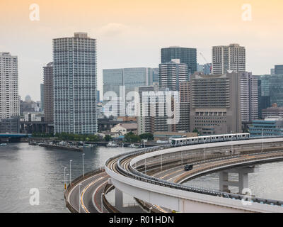 Moderna autostrada con automobili e il treno che conduce ad un ponte. Rainbow Bridge, Tokyo, Giappone. Foto Stock