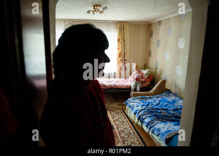 Sloviansk, Ucraina. 29 ott 2018. Kira Romanova (R) giocando nella casa di famiglia in un villaggio vicino a Sloviansk e di essere guardato da sua madre Nadezhda Romanova. La loro casa di proprietà e sono stati gravemente danneggiati in seguito a conflitti tra il militare ucraino e pro-russo separatisti in Ucraina orientale e in parte ricostruito e rinnovato dal tedesco di aiuti allo sviluppo. Credito: Gregor Fischer/dpa/Alamy Live News Foto Stock