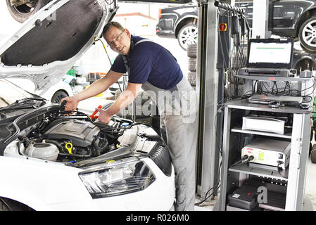 Autofficine la carica della batteria del veicolo in officina Foto Stock