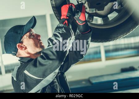 Il giunto sferico dello sterzo del veicolo dalla manutenzione professionale auto caucasica meccanico. Industria automobilistica. Foto Stock