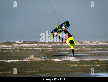 Kite surfer tocca l'acqua con la mano mentre viene capovolto Foto Stock