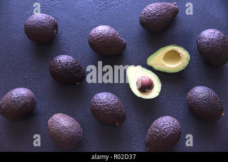 Avocadi Hass su sfondo scuro Foto Stock