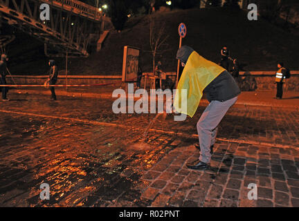 7 dicembre 2013 - Kiev, Ucraina: un uomo che versa acqua sul marciapiede in attesa che esso si blocca e rendere la strada scivolosa per le forze di polizia. Migliaia di manifestanti ucraini riuniti in piazza Indipendenza, ribattezzata "EuroMaidan', per protestare contro il loro governo con il rifiuto di uno storico patto commerciale con l'Unione europea (UE). I liberali e i nazionalisti braved miserabile inverno meteo e brutalità della polizia per respingere i funzionari del governo visto come subordinato alla Russia. Des dozzine de milliers de manifestants ukrainiens se rassemblent place de l'independance a Kiev pour protester contre Foto Stock