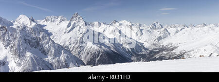 Coperta di neve sulle piste da sci contro lo sfondo delle vette. Vista panoramica del pittoresco paesaggio innevato. Il concetto di trave Foto Stock