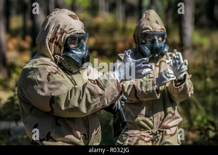 I candidati che partecipano per il campo di esperti medici pratica Badge indossabilità e rimozione di ingranaggio protettivo utilizzato durante attacchi chimici, biologici, radiologici e nucleari, per la fase di standardizzazione del EFMB sulla Fort Bragg, N.C., Ottobre 30, 2018. La prima settimana di test introduce i candidati di tutte le attività che saranno tenuti a completare per guadagnare l'ambita badge. Il EFMB fu stabilito per mostrare e riconoscere i soldati medica per la loro eccezionale livello di abilità e competenze in campo medico. La prova consiste in un esame scritto, navigazione terrestre, tre distinti pettine Foto Stock