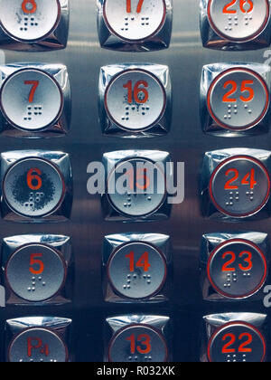 Pulsanti degli ascensori - numeri rossi sui pulsanti in metallo Foto Stock