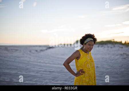 Giovane donna in abiti vintage sulla spiaggia Foto Stock