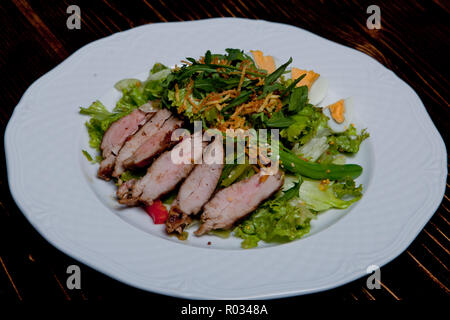 Gustosa satat. Ingredienti insalata mista, mini patate, asparagi, uovo, pepe bulgara, la carne di maiale tagliata, riempimento di senape Foto Stock