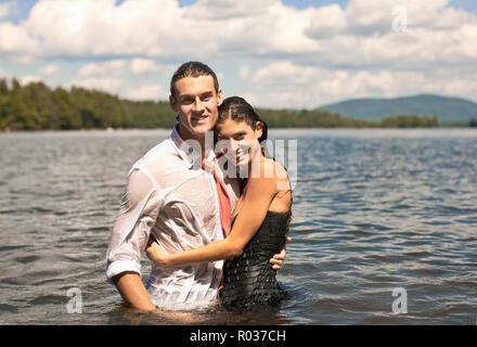 Vestito felice coppia in piedi in acqua. Foto Stock