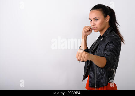 Studio shot della giovane donna asiatica guardando al lato con entrambe f Foto Stock