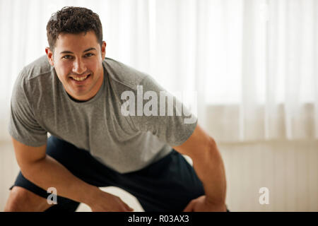 Focalizzato giovane stretching prima di esercitare. Foto Stock