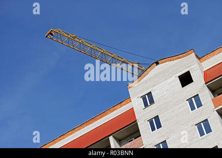 Costruzione di braccio della gru su costruzione contro un cielo blu Foto Stock