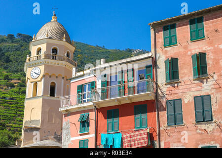 Vista la medievale torre dell orologio delle Cinque Terre, Italia con case colorate in una giornata di sole. Foto Stock