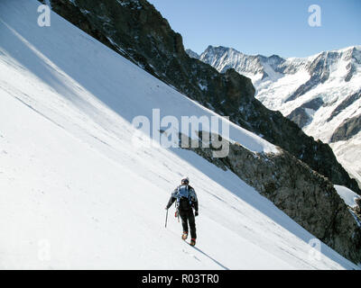 L'alpinista escursionismo giù da solo su una ripida gelido ghiacciaio delle Alpi svizzere al di sopra di Grindelwald Foto Stock