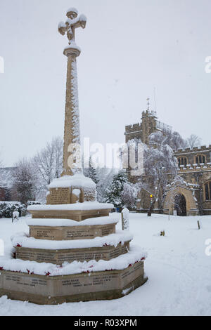 Memoriale di guerra e la chiesa parrocchiale di San Pietro e di San Paolo in città mercato di Tring Hertfordshire, Inghilterra coperto di neve durante l'inverno blizzard Foto Stock