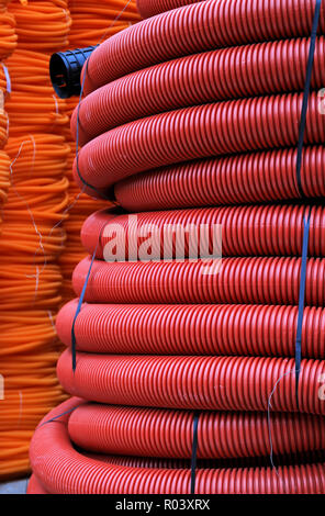 Grande pila di rosso cavi di plastica in bobine Foto Stock