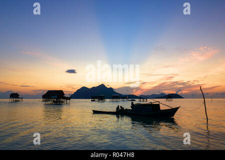 Bellissima alba con la barca e casa costruita stilt su acqua a Isola Maiga Semporna Sabah Foto Stock