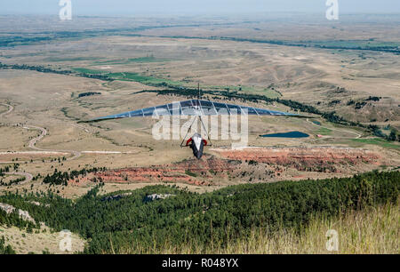 Il deltaplano in Wyoming: un aliante le vele oltre il paesaggio del nordest del Wyoming dopo il lancio da una rupe in Big Horn Mountains. Foto Stock