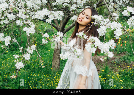 Ritratto di giovane ragazza in abito bianco in Apple Blossom Garden Foto Stock