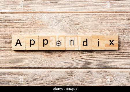 Appendice parola scritta sul blocco di legno. appendice del testo in tabella, concetto. Foto Stock