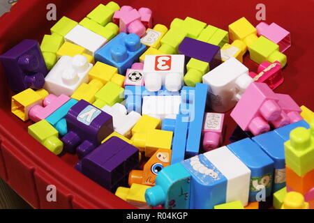 Carro rosso riempito con colorati bambino blocchi di costruzione Foto Stock