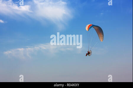 Powered parapendio volare in un cielo blu chiaro Foto Stock