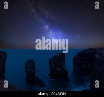 Incredibile vibrante via lattea immagine composita oltre il paesaggio di Elegug pile su di Pembrokeshire Coast in Galles Foto Stock