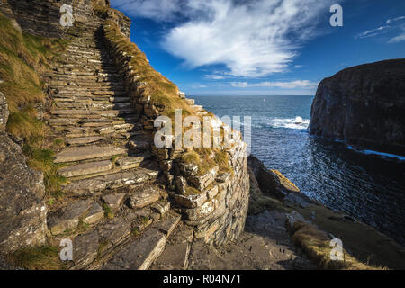 Whaligoe passi - ripide scale pietroso conduce tutti la strada verso la piccola spiaggia al di sotto di alte scogliere vicino villaggio Whaligoe, Highlands della Scozia. Foto Stock