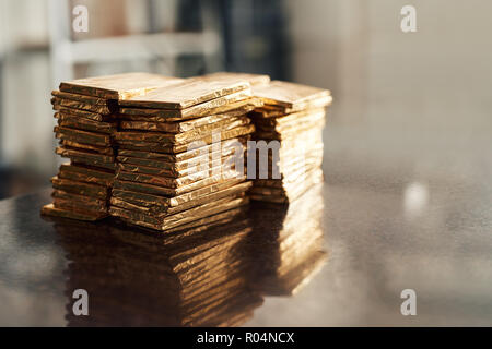 Pile di freschi barrette di cioccolato in lamina d'oro Foto Stock