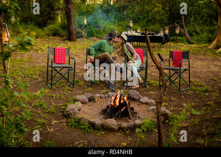 Giovane baciare da un safari camp falò in Zululand, Sud Africa e Africa Foto Stock