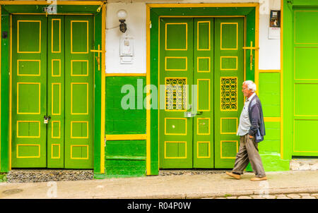 Un uomo locale oltrepassando un tipicamente colorate, conserve, Edificio coloniale, Jardin, Colombia, Sud America Foto Stock