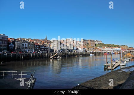 Una vista di Whitby, North Yorkshire, Regno Unito dalla Città Vecchia guardando attraverso il porto in una luminosa giornata autunnale con un profondo blu cielo senza nuvole. Foto Stock