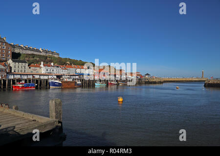 Una vista di Whitby, North Yorkshire, Regno Unito dalla Città Vecchia guardando attraverso il porto in una luminosa giornata autunnale con un profondo blu cielo senza nuvole. Foto Stock