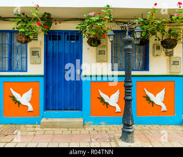 La facciata di un edificio colorato contemplati nei tradizionali mattonelle locali, nella pittoresca cittadina di Guatape, Colombia, Sud America Foto Stock